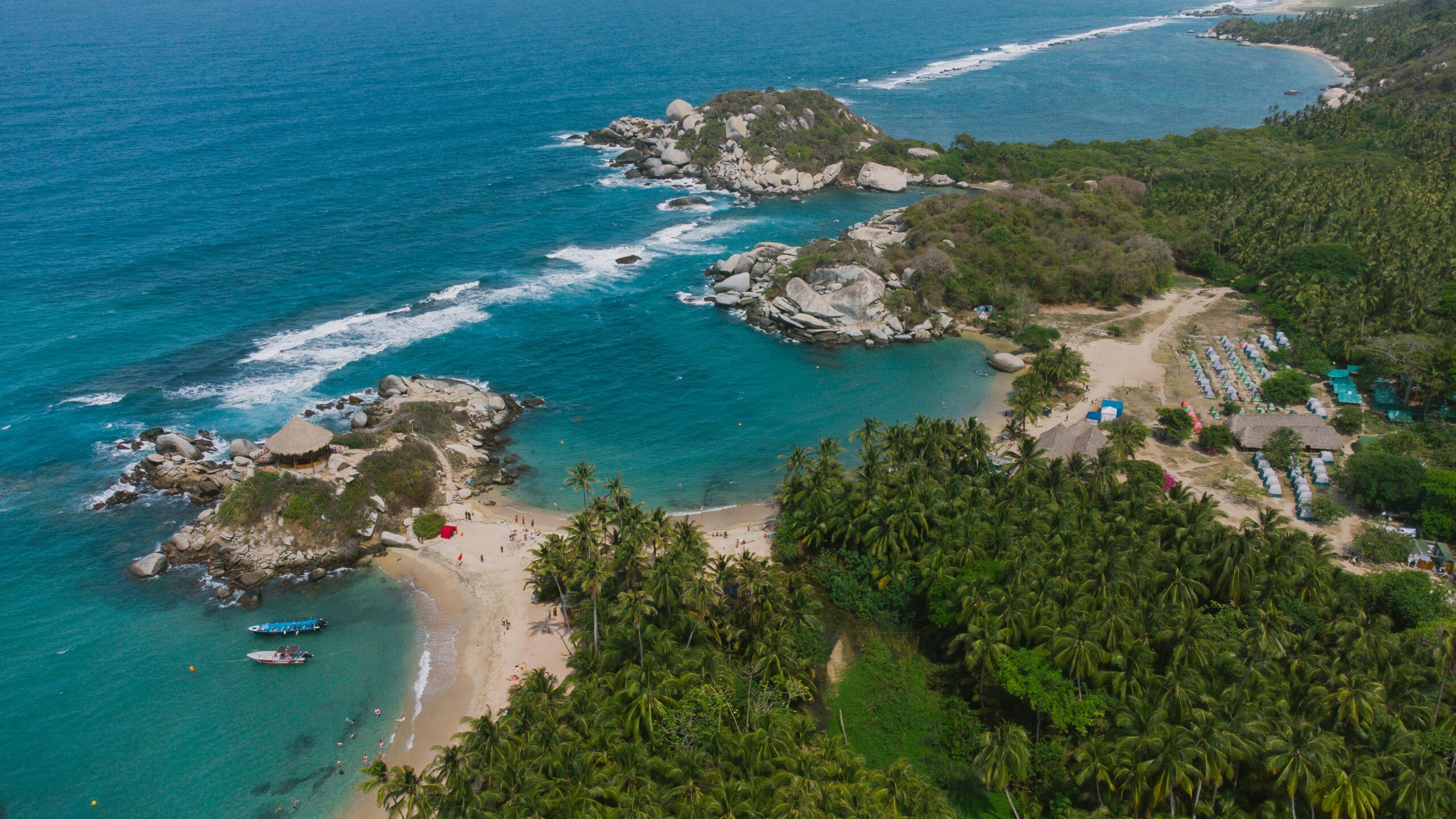 Stunning aerial drone shot of Tayrona National Park's coastline in Colombia, showcasing turquoise waters and lush greenery.